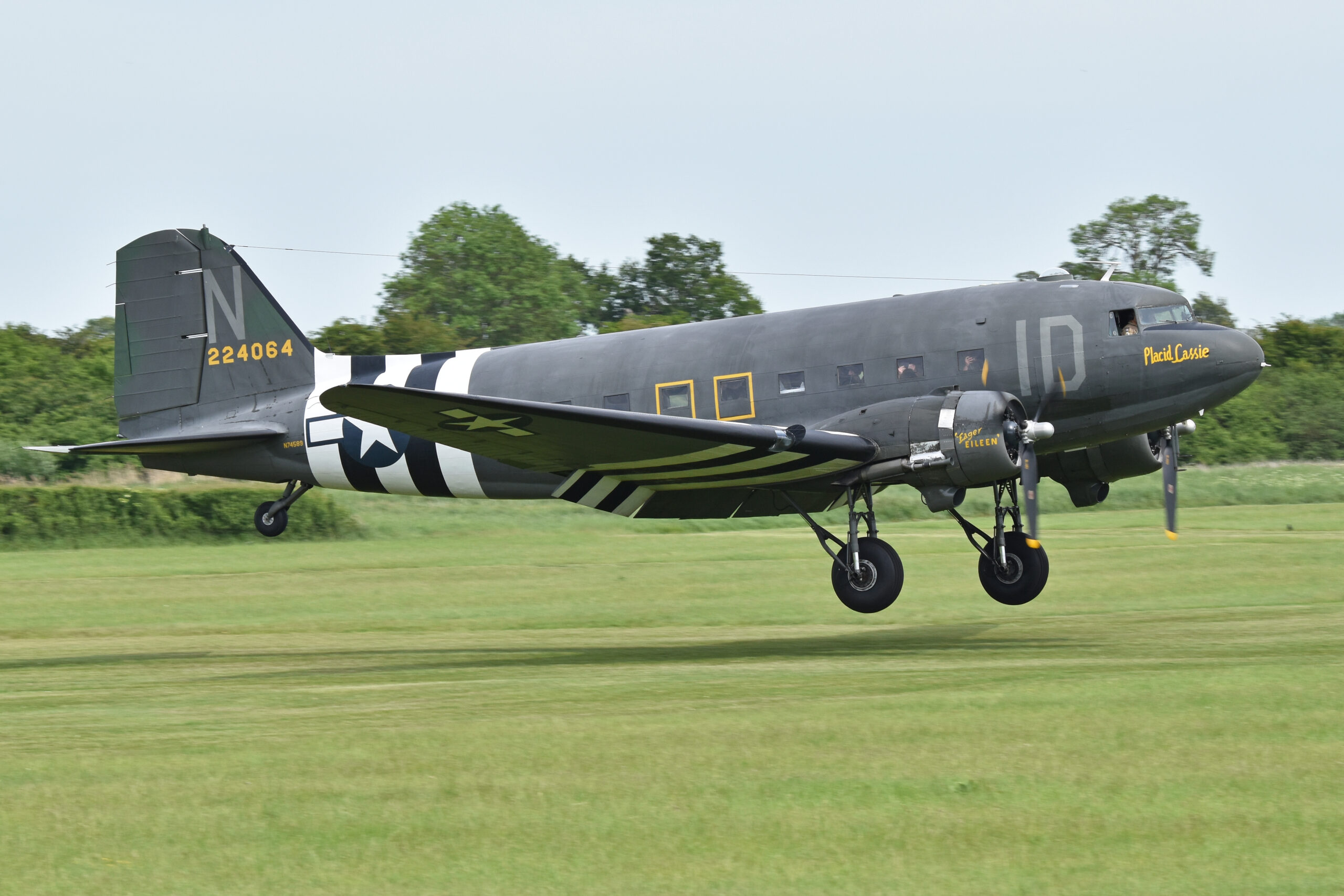 Word War II era C47 taking off on a grass air field